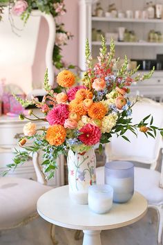 a white table topped with a vase filled with flowers