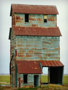 an old building with rusted tin roof in the middle of nowhere