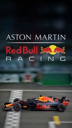 a red bull racing car driving down a track with the words aston martin on it