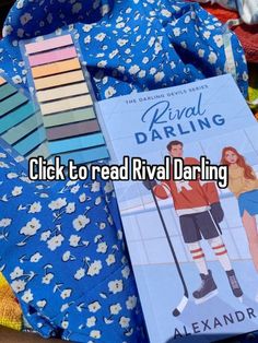 a book sitting on top of a bed next to a blue flowered blanket with the title click to read rival daring