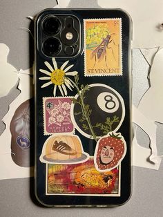 a cell phone case with stamps and flowers on the back, sitting on a table