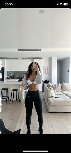 a woman is taking a selfie in her living room while wearing leggings