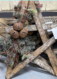 an old wooden star decorated with pine cones and red berries