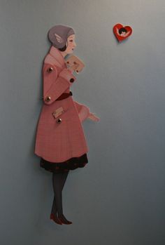 a paper cut out of a woman wearing a pink coat