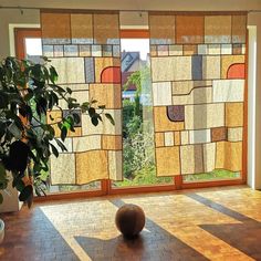 a basketball sitting on top of a hard wood floor in front of a large window