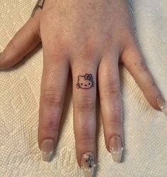 a person's hand with a hello kitty tattoo on it