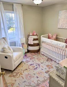 a baby's room with a crib, rocking chair, and large rug