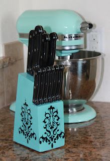 a blue stand mixer sitting on top of a counter next to a teal colored mixer