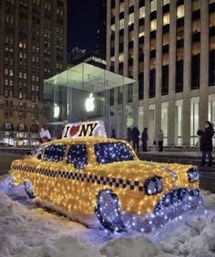 a taxi decorated with christmas lights in the snow