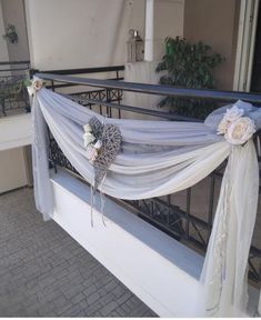 a balcony decorated with white flowers and sheer drapes for an outdoor wedding ceremony or special occasion