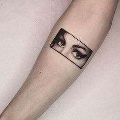 a person's arm with an eye on it and a black and white photo