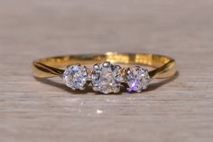 three stone ring sitting on top of a wooden table