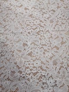 an old lace tablecloth with white flowers on it