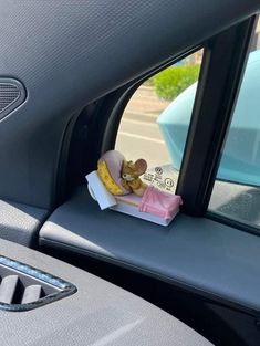 a stuffed animal sitting in the passenger seat of a car