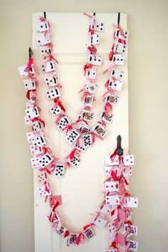 a number of cards attached to a door with clothes pins and ribbons hanging from them