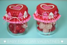 two jars filled with candy sitting on top of a blue table next to each other