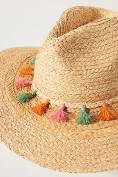 a straw hat with colorful tassels on it