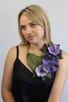 a woman wearing a black dress and purple flowers