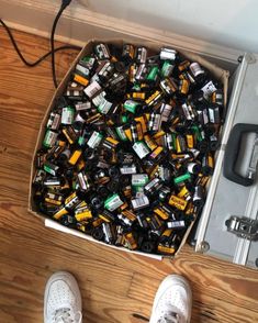 a box filled with lots of different types of beer bottles next to a pair of white shoes