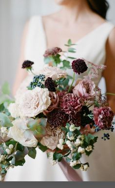 a bridal holding a bouquet of flowers and greenery