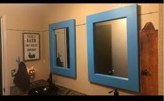 a bathroom with two blue framed mirrors on the wall