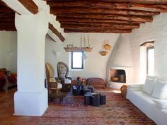 a living room filled with furniture and a fire place in the middle of a room