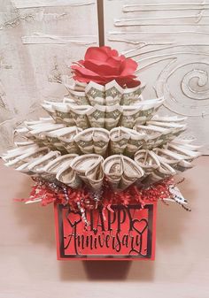 a red and white card that says happy anniversary with money in the shape of a christmas tree