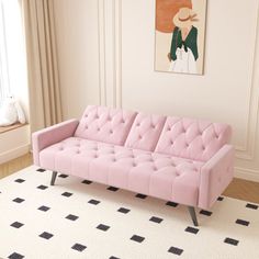 a pink couch sitting on top of a white rug next to a window in a living room