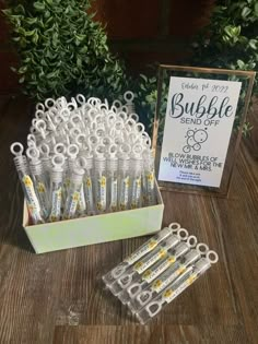 a box filled with lots of white and yellow toothbrushes sitting on top of a wooden table