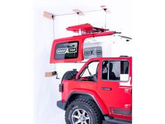 a red and white jeep with a roof top on it's flatbeds