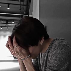 a woman sitting down with her hands on her face