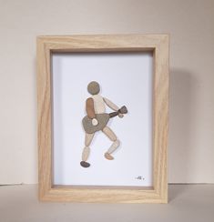 a wooden frame with a paper cut out of a man holding a guitar