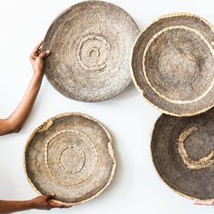 four baskets are arranged on top of each other, with one being held by two hands