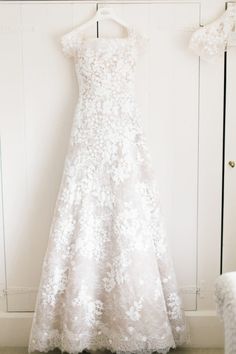 a wedding dress hanging on a white door