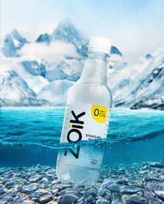 a bottle of water sitting on top of a rocky beach