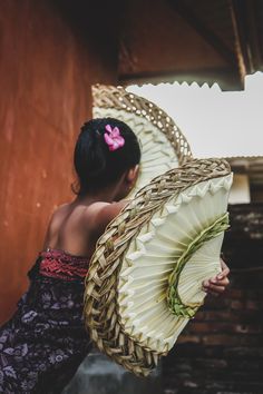 a woman holding a large fan in her hand