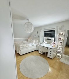 a bedroom with a bed, desk and chair next to a large white rug on the floor