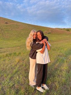 two women hugging each other in a field