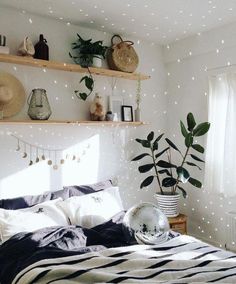 a bed room with a neatly made bed and some plants