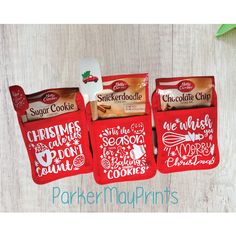 three red christmas cookie bags sitting on top of a wooden table