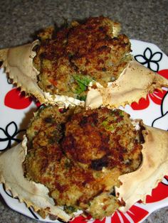 three crab cakes sitting on top of a red and white plate