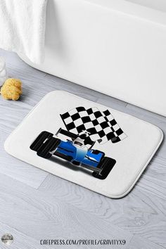 a bath mat with a blue race car on it and checkered flag in the background