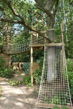 a tree house built into the side of a tree in a park with a slide