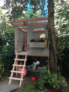 a tree house built into the side of a tree in a yard with stairs leading up to it