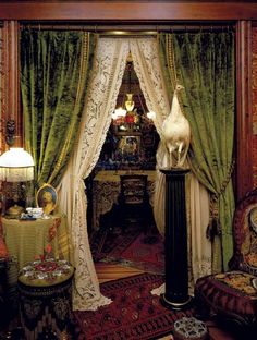 an elaborately decorated living room with green drapes