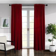 a white chair sitting in front of a red curtain