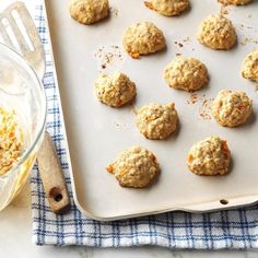 freshly baked cookies on a baking sheet next to a bowl of oatmeal