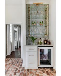 a kitchen with white cabinets and glass shelves on the wall above an open microwave oven