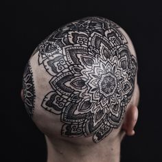 a man's head with an intricate tattoo on it