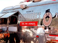 a large silver trailer with an advertisement for doughnuts on it's side